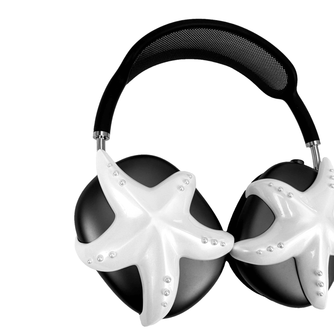 Apple over-ear headphones adorned with a metallic starfish sculpture and dot-like spheres, evoking constellations and marine elegance.
