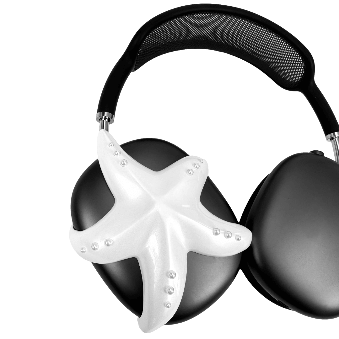 Apple over-ear headphones adorned with a metallic starfish sculpture and dot-like spheres, evoking constellations and marine elegance.