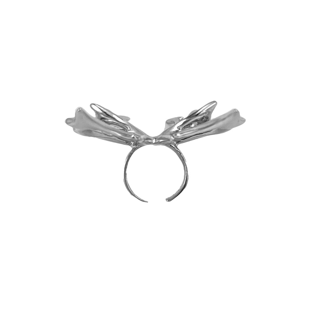 Chrome thorned butterfly-shaped accessory clipped onto AirPods Max.