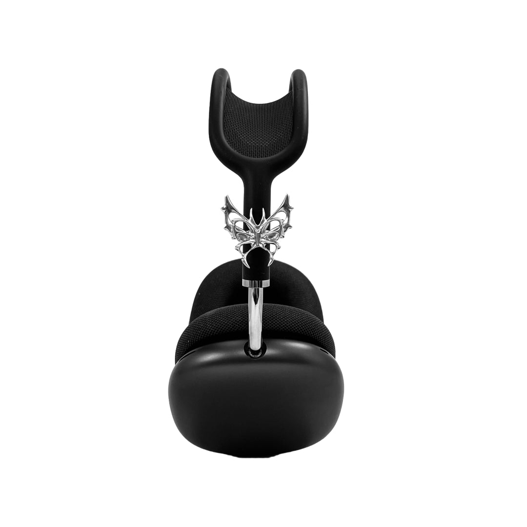 Chrome thorned butterfly-shaped accessory clipped onto AirPods Max.