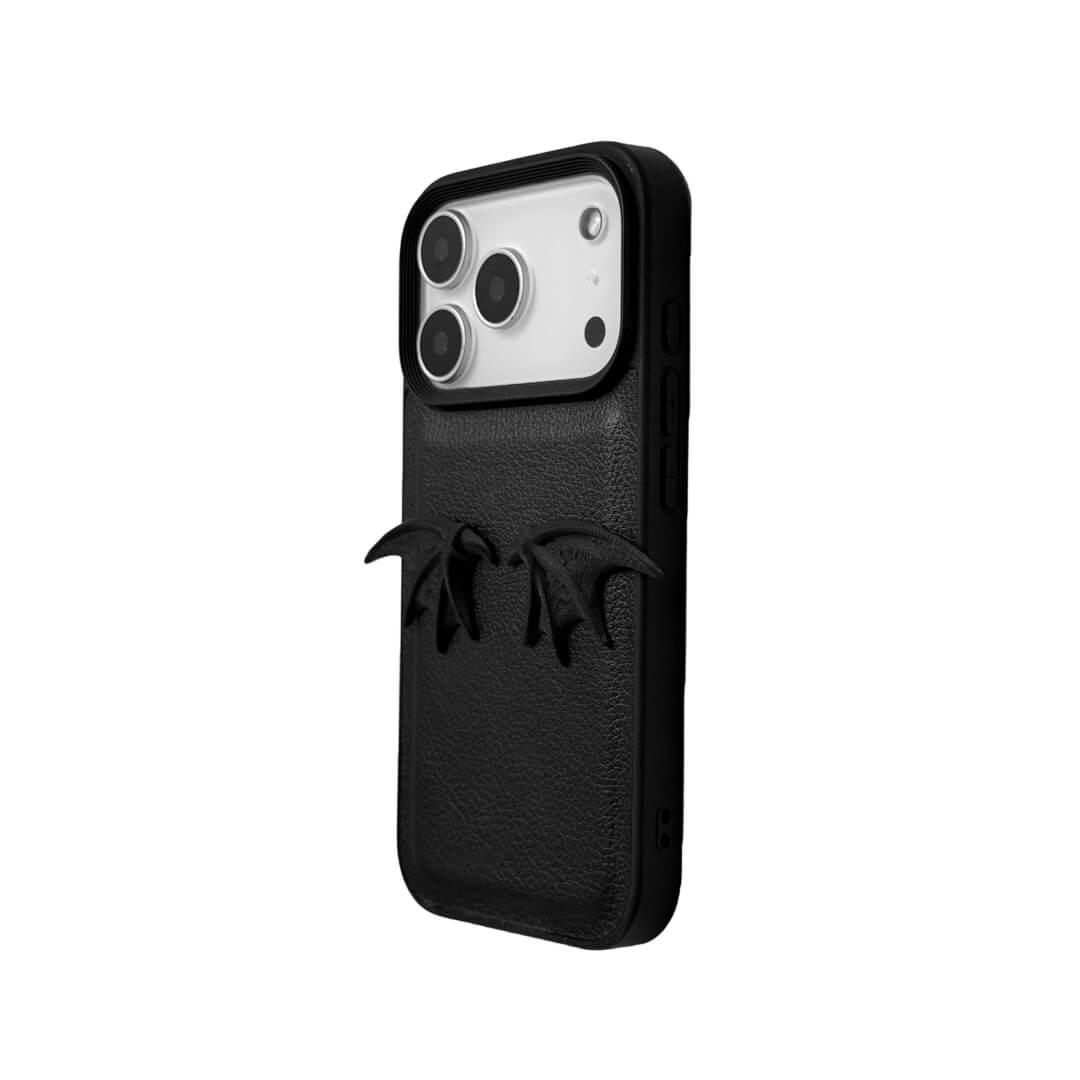 A minimalist iPhone case featuring a pair of miniature 3D-printed demon wings in a natural matte black finish. Available in two variations: a Clear Transparent base for a floating effect, and a Black Leather textured base for a rich, monochromatic Gothic aesthetic.