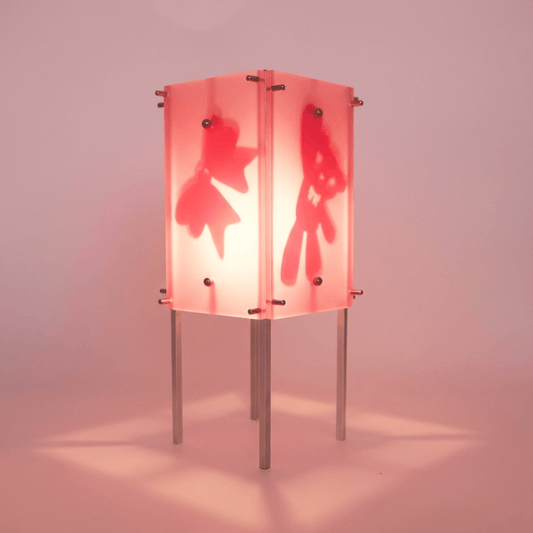 Lamp with red hand-shaped cutouts on a pink background