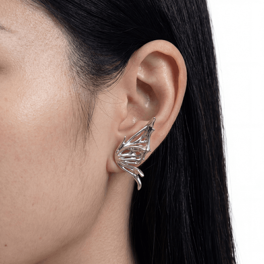 Silver leaf-shaped earring worn by a person with dark hair.