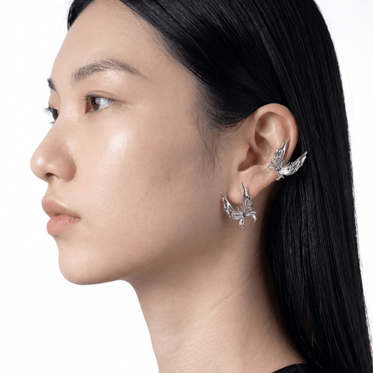 Close-up of a woman wearing butterfly-shaped earrings on a white background