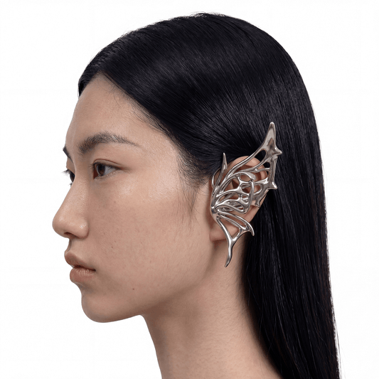 Person wearing a silver leaf-like earring on a white background