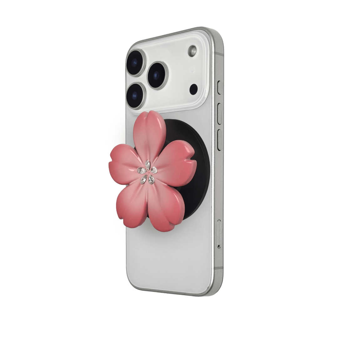 Magnetic phone grip with a silver mirror finish, decorated with a cherry blossom in pink or silver tones accented by five sparkling crystals for a luxurious, floral-inspired look.