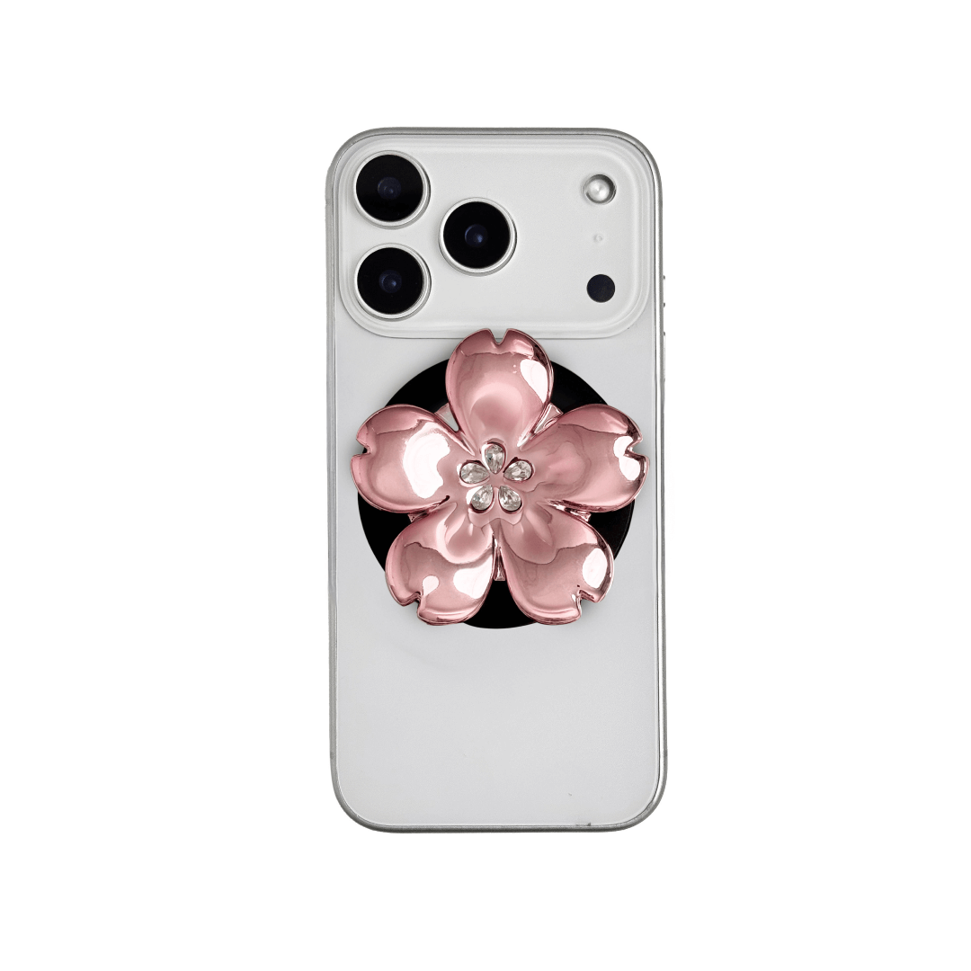 Magnetic phone grip with a silver mirror finish, decorated with a cherry blossom in pink or silver tones accented by five sparkling crystals for a luxurious, floral-inspired look.