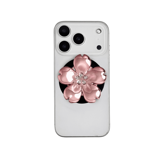 Magnetic phone grip with a silver mirror finish, decorated with a cherry blossom in pink or silver tones accented by five sparkling crystals for a luxurious, floral-inspired look.