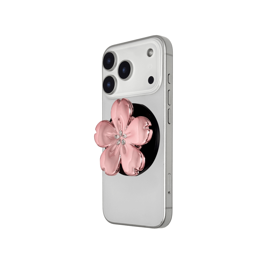 Magnetic phone grip with a silver mirror finish, decorated with a cherry blossom in pink or silver tones accented by five sparkling crystals for a luxurious, floral-inspired look.