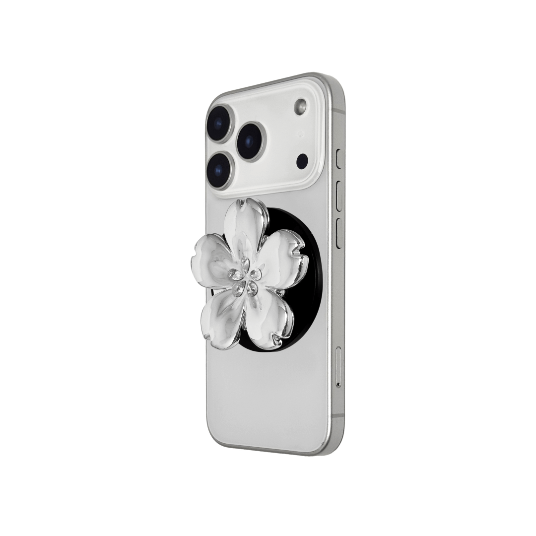 Magnetic phone grip with a silver mirror finish, decorated with a cherry blossom in pink or silver tones accented by five sparkling crystals for a luxurious, floral-inspired look.