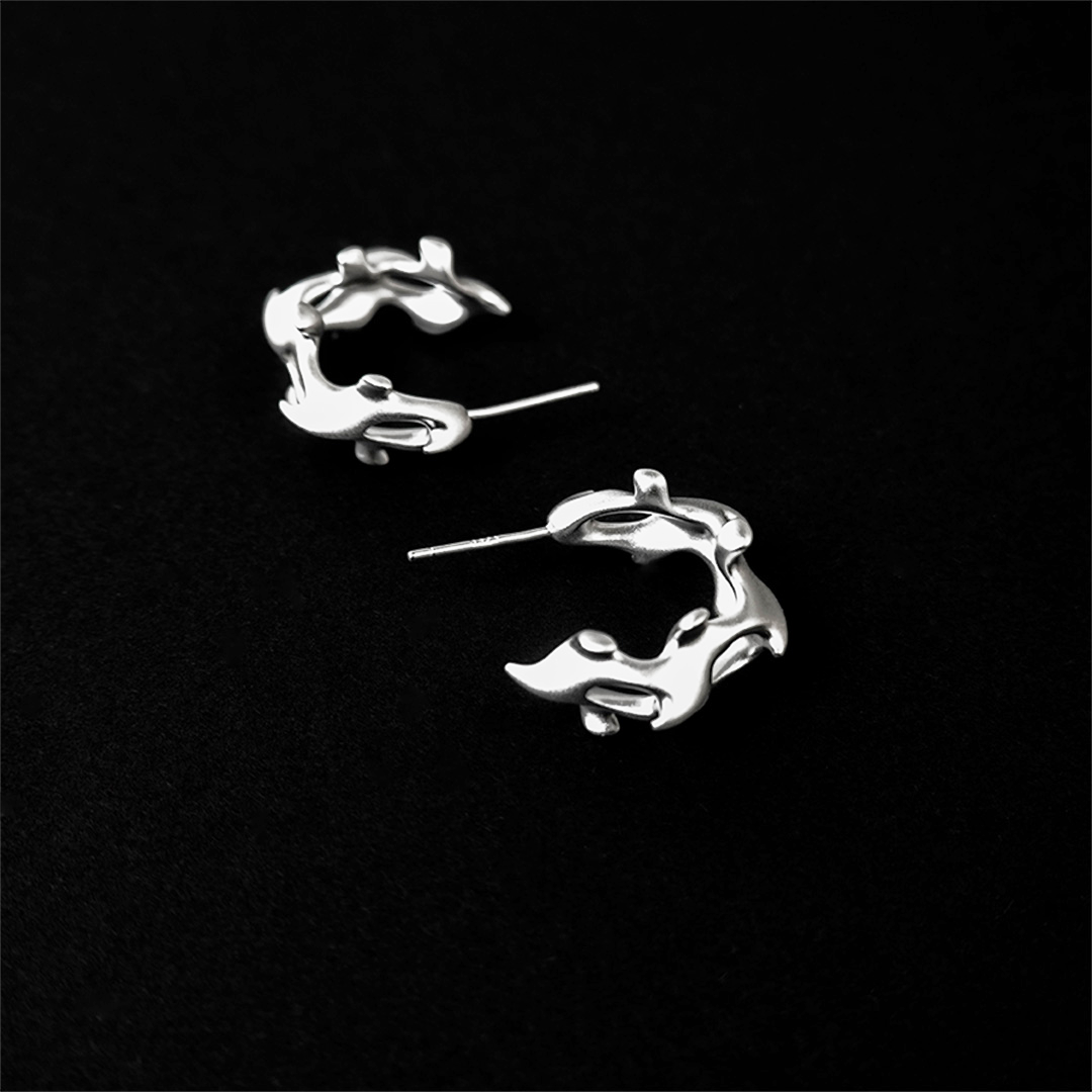 Silver earrings on a black background