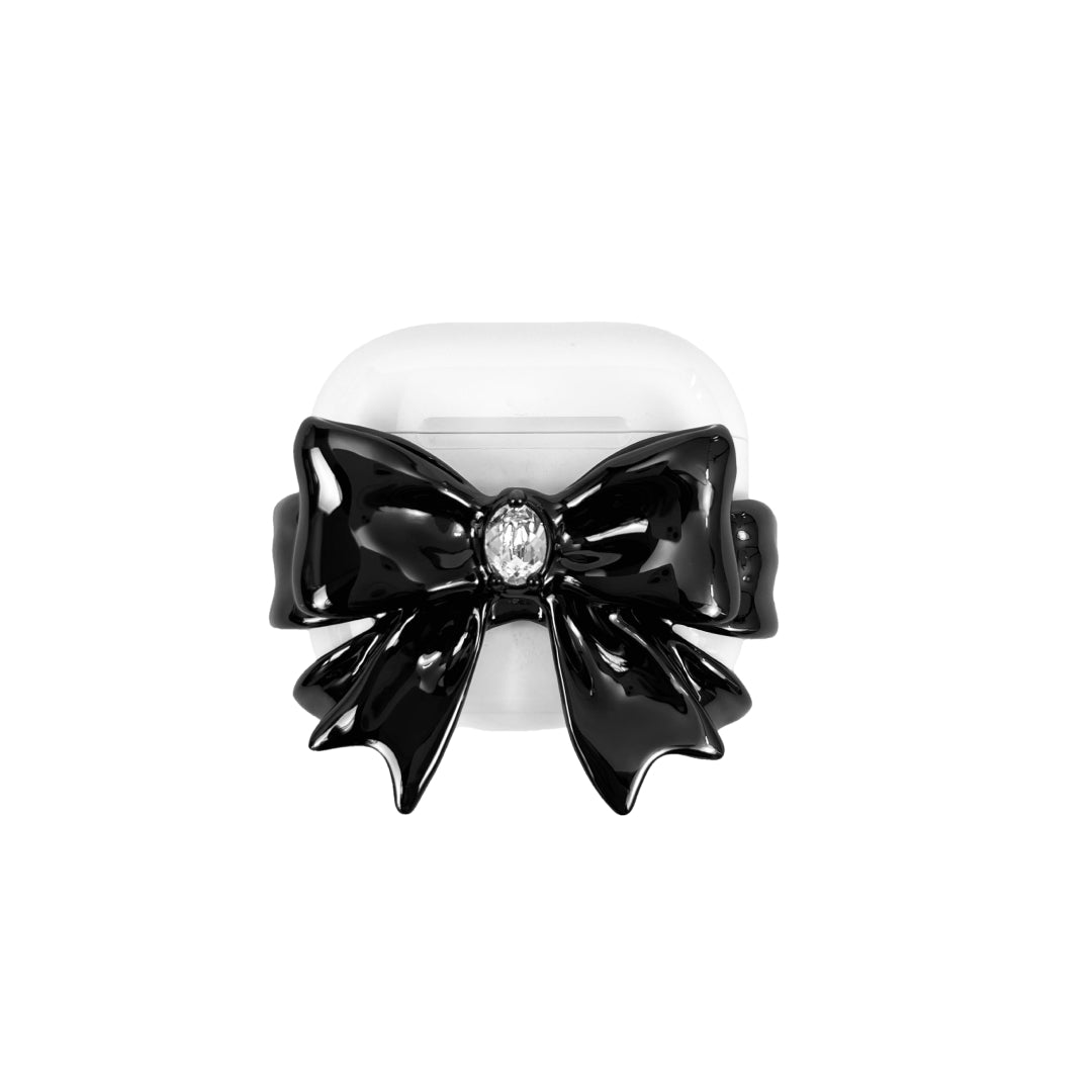airpods cover, gem, bow, black, white, xtended identity: Sophisticated black bow-shaped AirPods case with a central sparkling Swarovski crystal, finished in 18K platinum plated metallic black, dark coquette style.
中央にスワロフスキークリスタルをあしらった、洗練された黒のリボン型AirPodsケース。18Kプラチナメッキを施したメタリックブラック仕上げ。