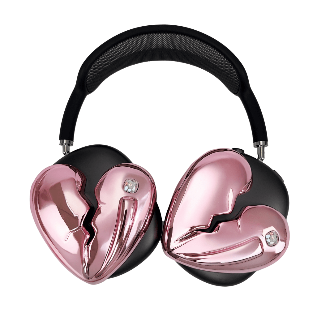Silver, pink, red and black AirPods Max cover featuring a metallic broken heart design, with a sculpted crack down the center and small embedded crystal detail.