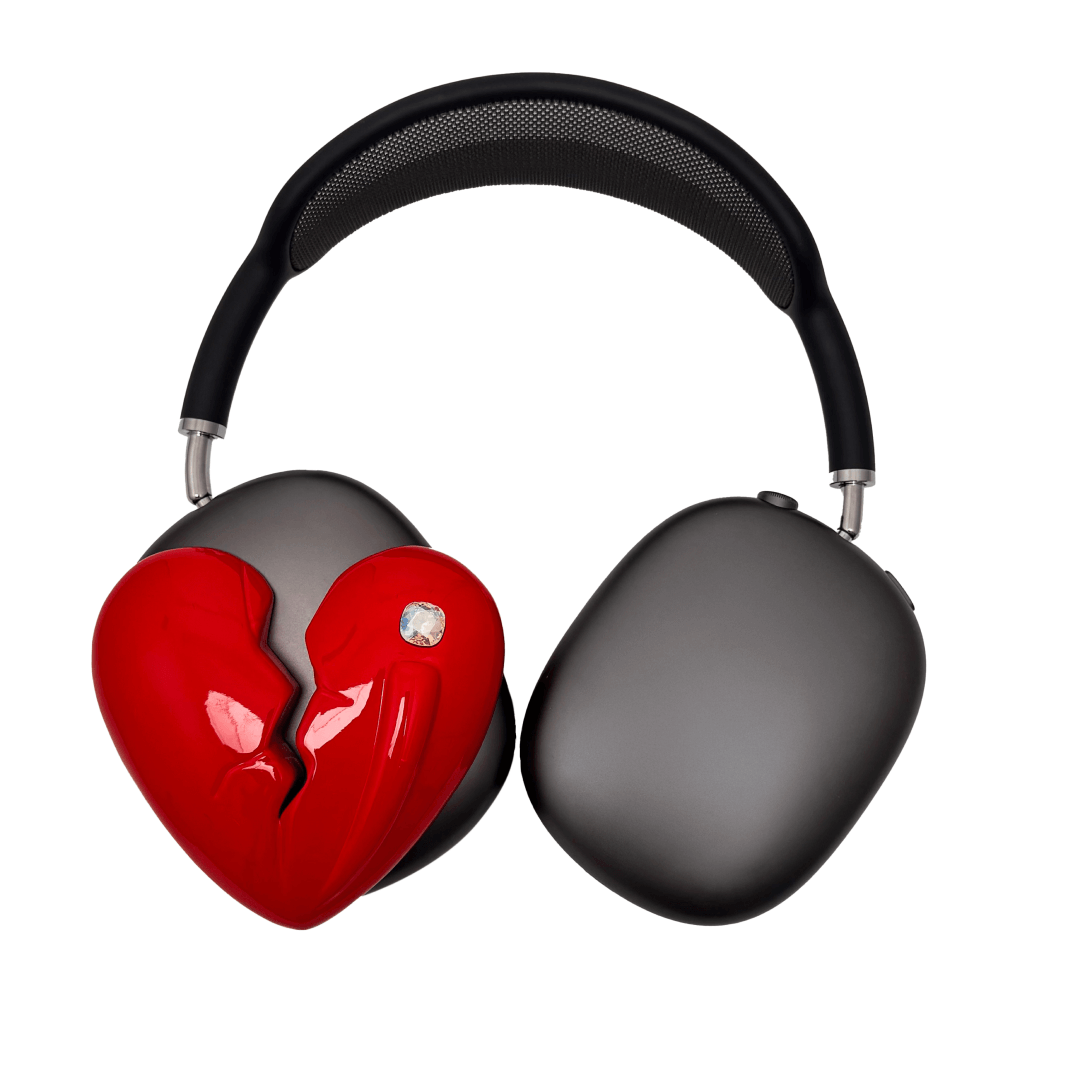 Silver, pink, red and black AirPods Max cover featuring a metallic broken heart design, with a sculpted crack down the center and small embedded crystal detail.