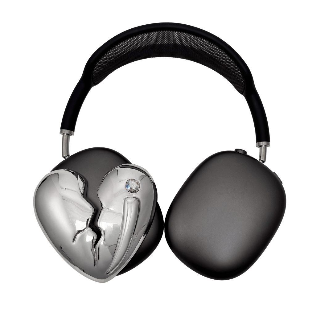 Silver, pink, red and black AirPods Max cover featuring a metallic broken heart design, with a sculpted crack down the center and small embedded crystal detail.