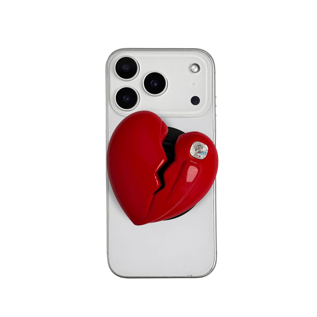 3D silver, pink, red and black metallic Phone grip featuring a cracked heart design with smooth chrome finish and a single embedded gem.