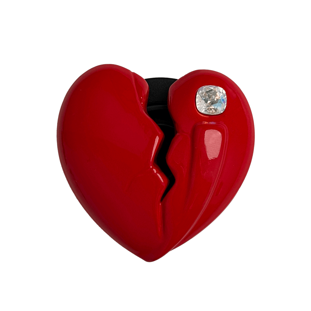3D silver, pink, red and black metallic Phone grip featuring a cracked heart design with smooth chrome finish and a single embedded gem.