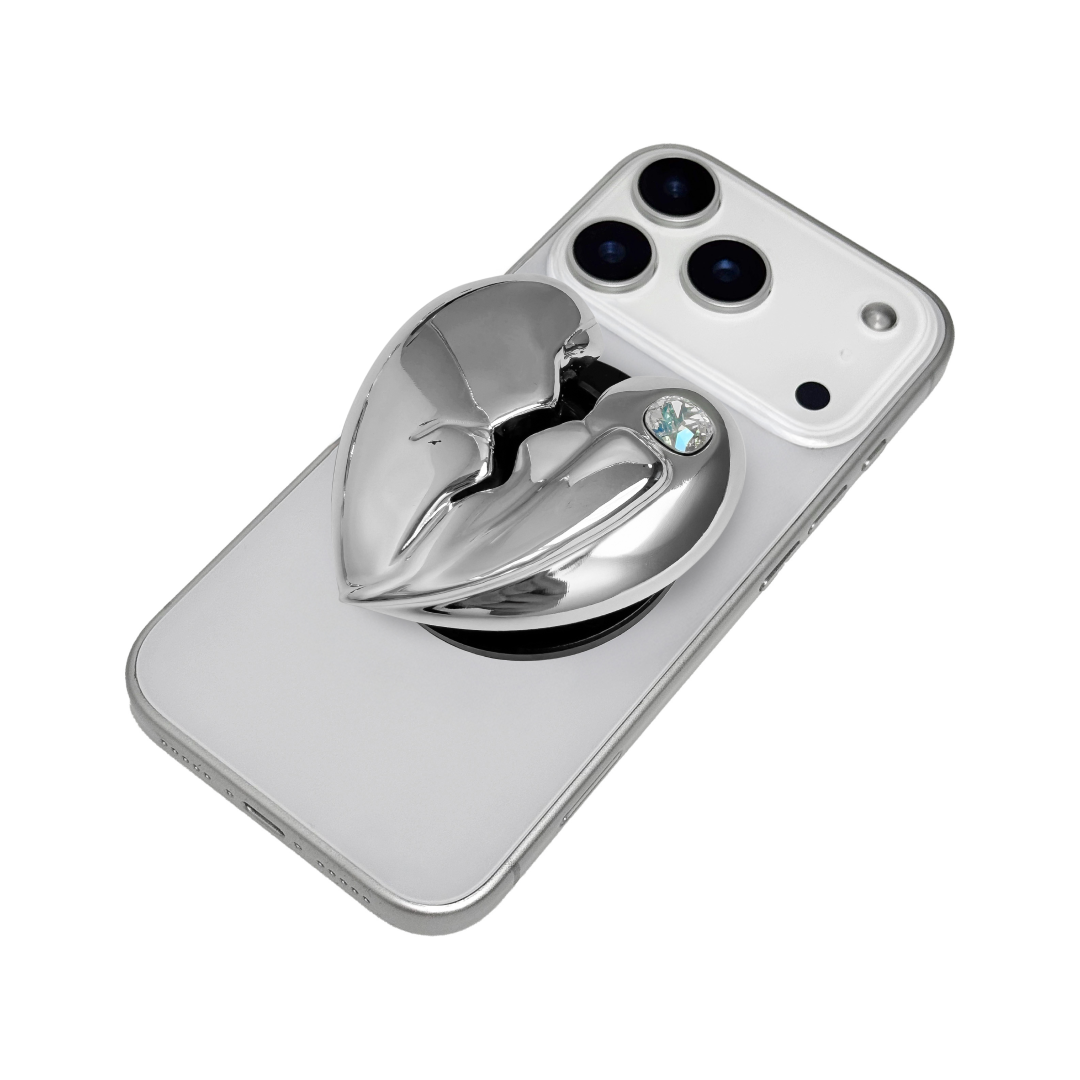 3D silver, pink, red and black metallic Phone grip featuring a cracked heart design with smooth chrome finish and a single embedded gem.