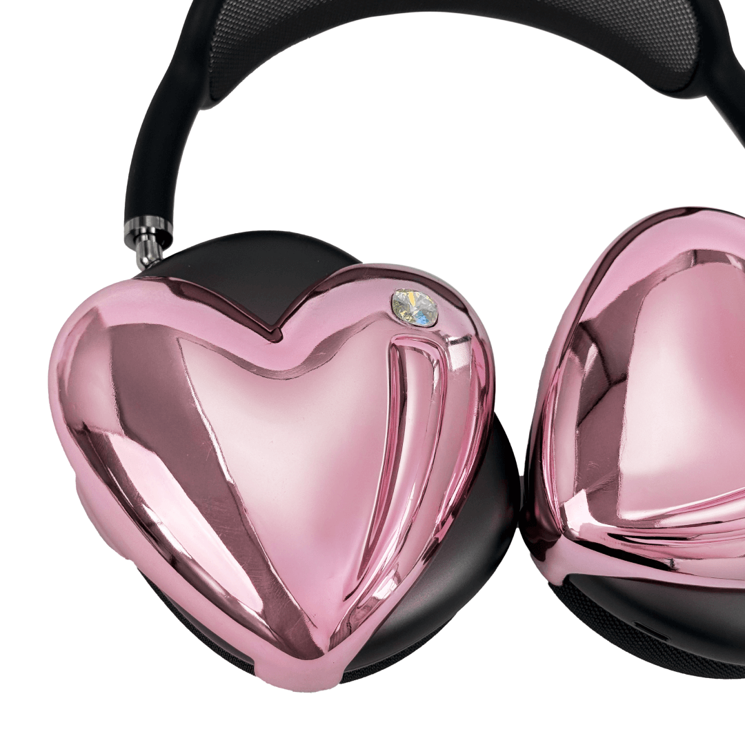 Metallic heart-shaped AirPods Max cover in silver, pink, red and black, with a smooth 3D sculpted surface and a single crystal stud detail.