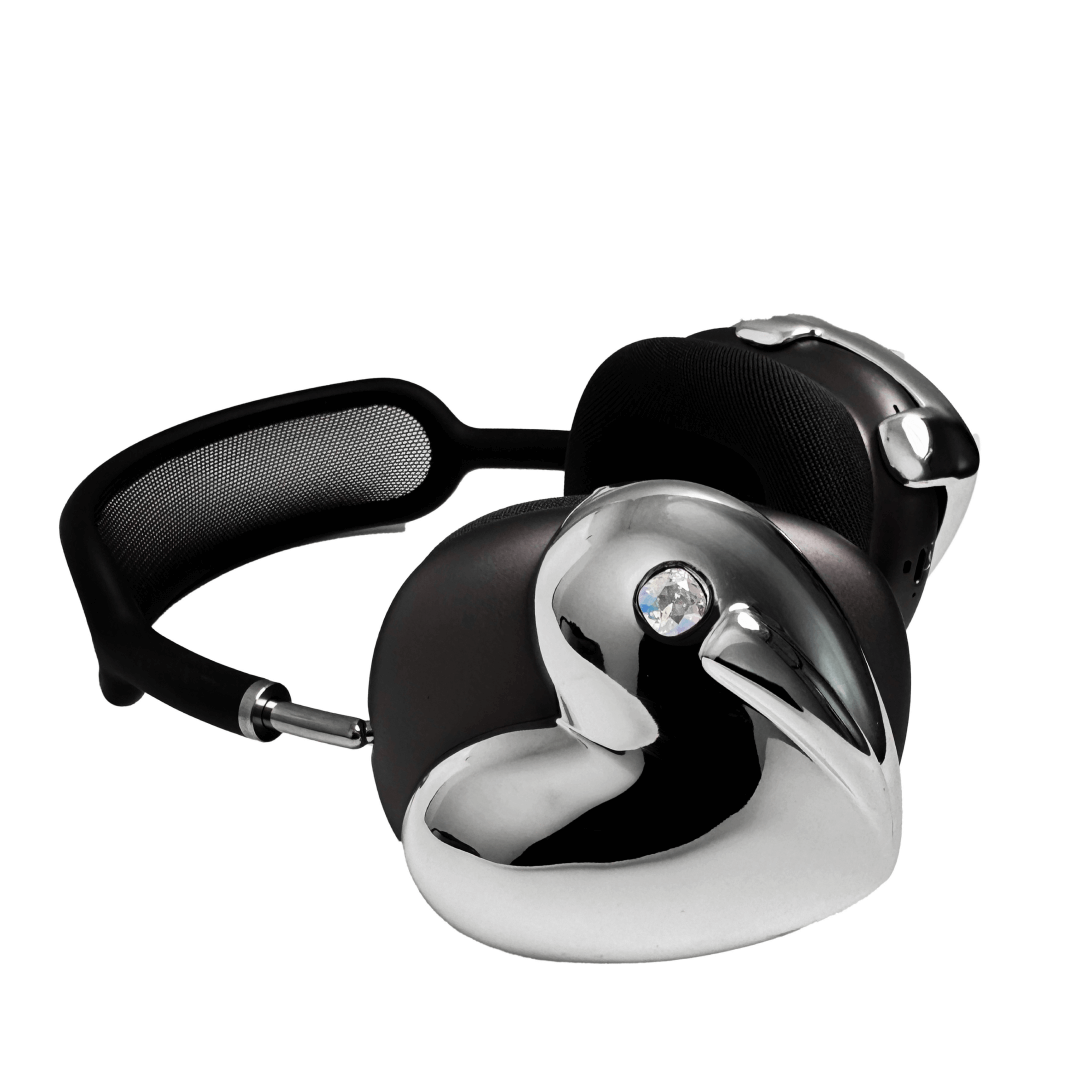 Metallic heart-shaped AirPods Max cover in silver, pink, red and black, with a smooth 3D sculpted surface and a single crystal stud detail.