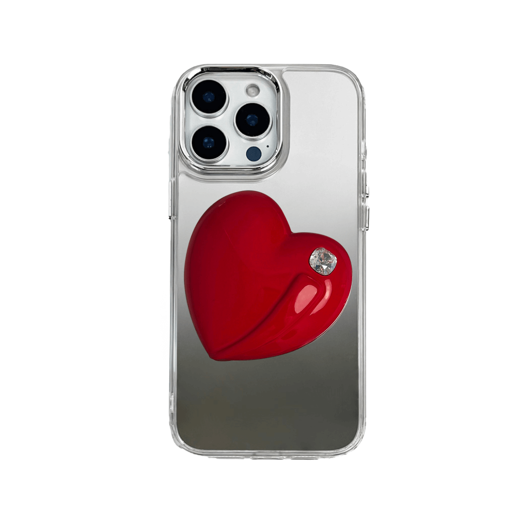 Metallic silver, pink, red, black iPhone case with a large sculpted heart in 3D, featuring a shiny chrome finish and a single gem-like detail.