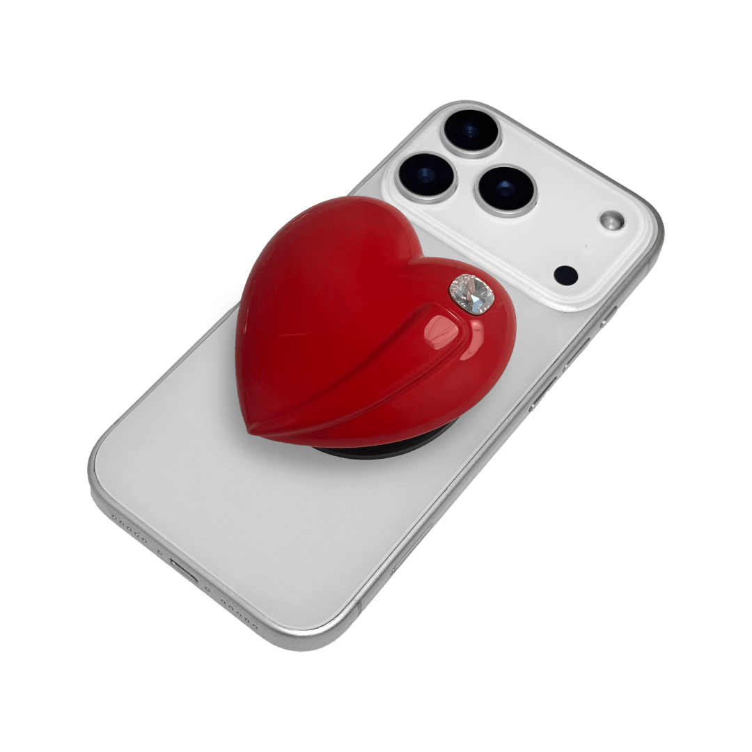 Metallic silver, pink, red, black Phone grip with a large sculpted heart in 3D, featuring a shiny chrome finish and a single gem-like detail.