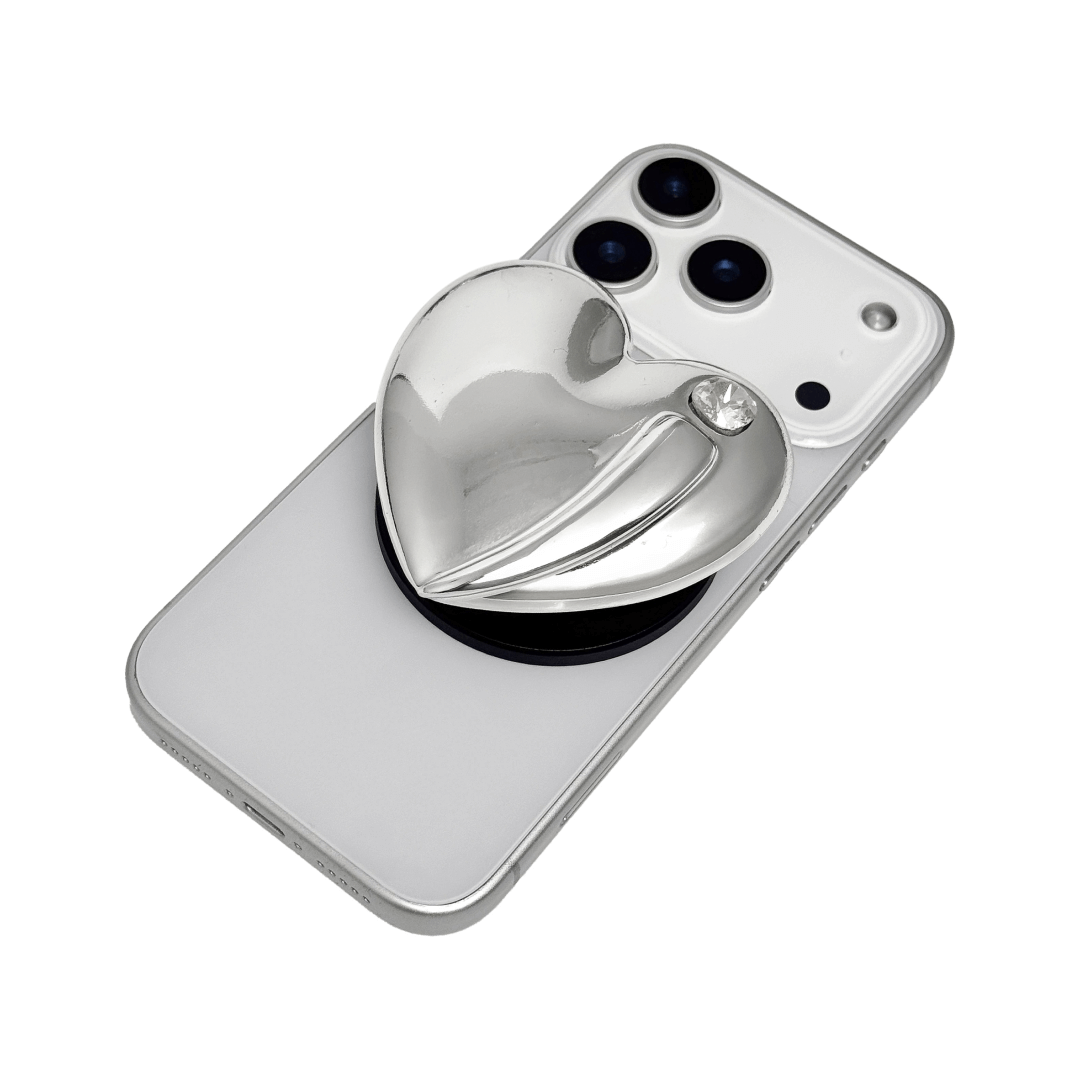 Metallic silver, pink, red, black Phone grip with a large sculpted heart in 3D, featuring a shiny chrome finish and a single gem-like detail.