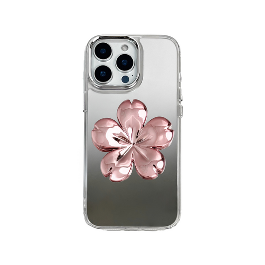 Silver mirror-finish iPhone case decorated with a pink and silver cherry blossom flower, combining a reflective modern surface with floral elegance.
