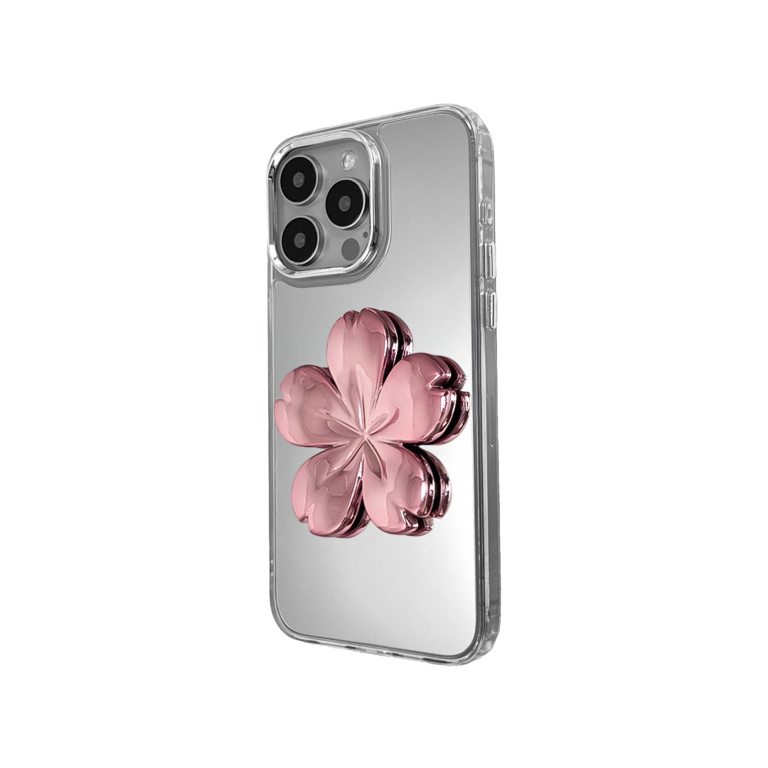 Silver mirror-finish iPhone case decorated with a pink and silver cherry blossom flower, combining a reflective modern surface with floral elegance.