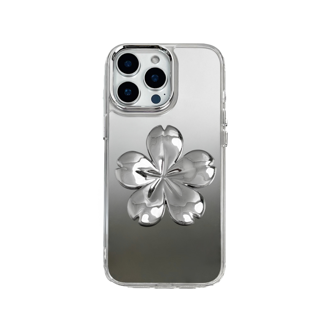 Silver mirror-finish iPhone case decorated with a pink and silver cherry blossom flower, combining a reflective modern surface with floral elegance.