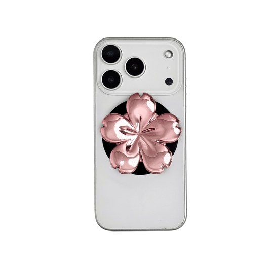 Magnetic phone grip with a silver mirror finish, decorated with a pink and silver cherry blossom flower for an elegant floral look.