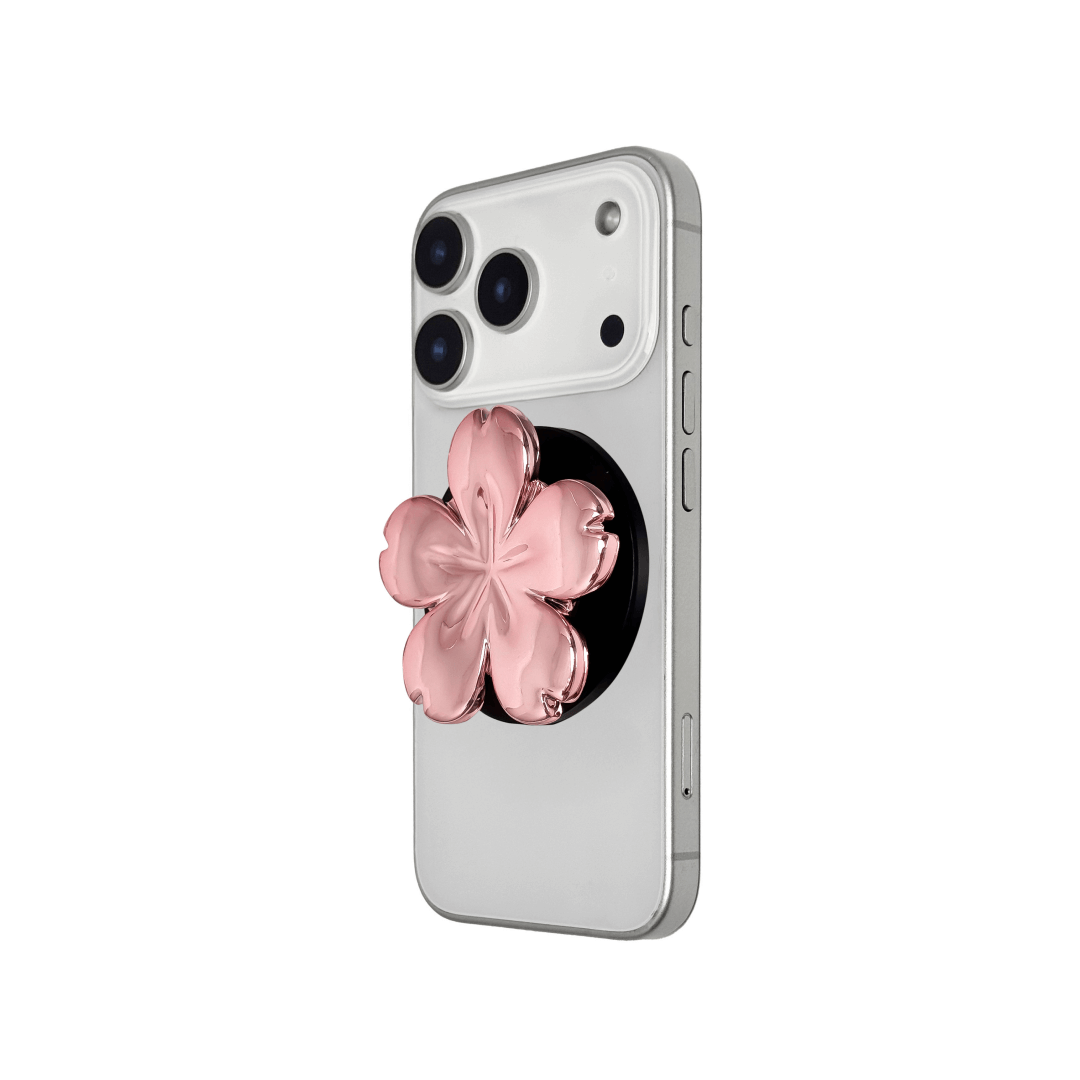 Magnetic phone grip with a silver mirror finish, decorated with a pink and silver cherry blossom flower for an elegant floral look.
