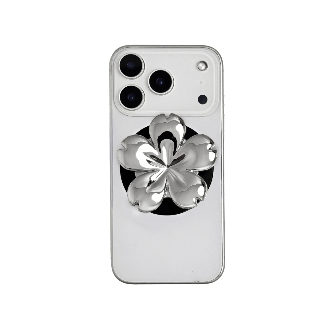 Magnetic phone grip with a silver mirror finish, decorated with a pink and silver cherry blossom flower for an elegant floral look.