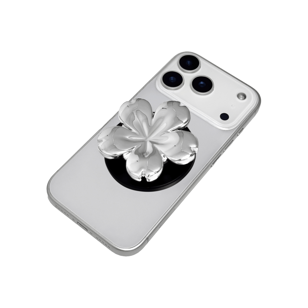 Magnetic phone grip with a silver mirror finish, decorated with a pink and silver cherry blossom flower for an elegant floral look.