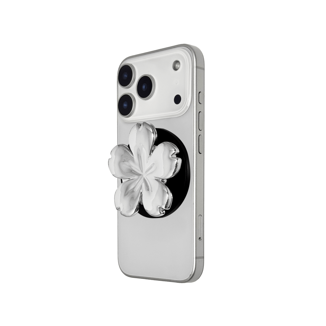 Magnetic phone grip with a silver mirror finish, decorated with a pink and silver cherry blossom flower for an elegant floral look.